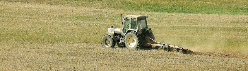 Zdjęcie przedstawia traktor pracujący na polu